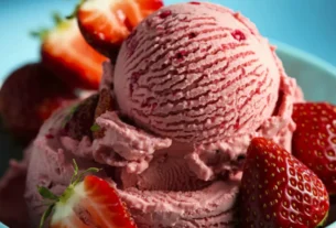 Sorvete de morango cremoso servido em tigela com morangos frescos, textura artesanal e cor natural da fruta